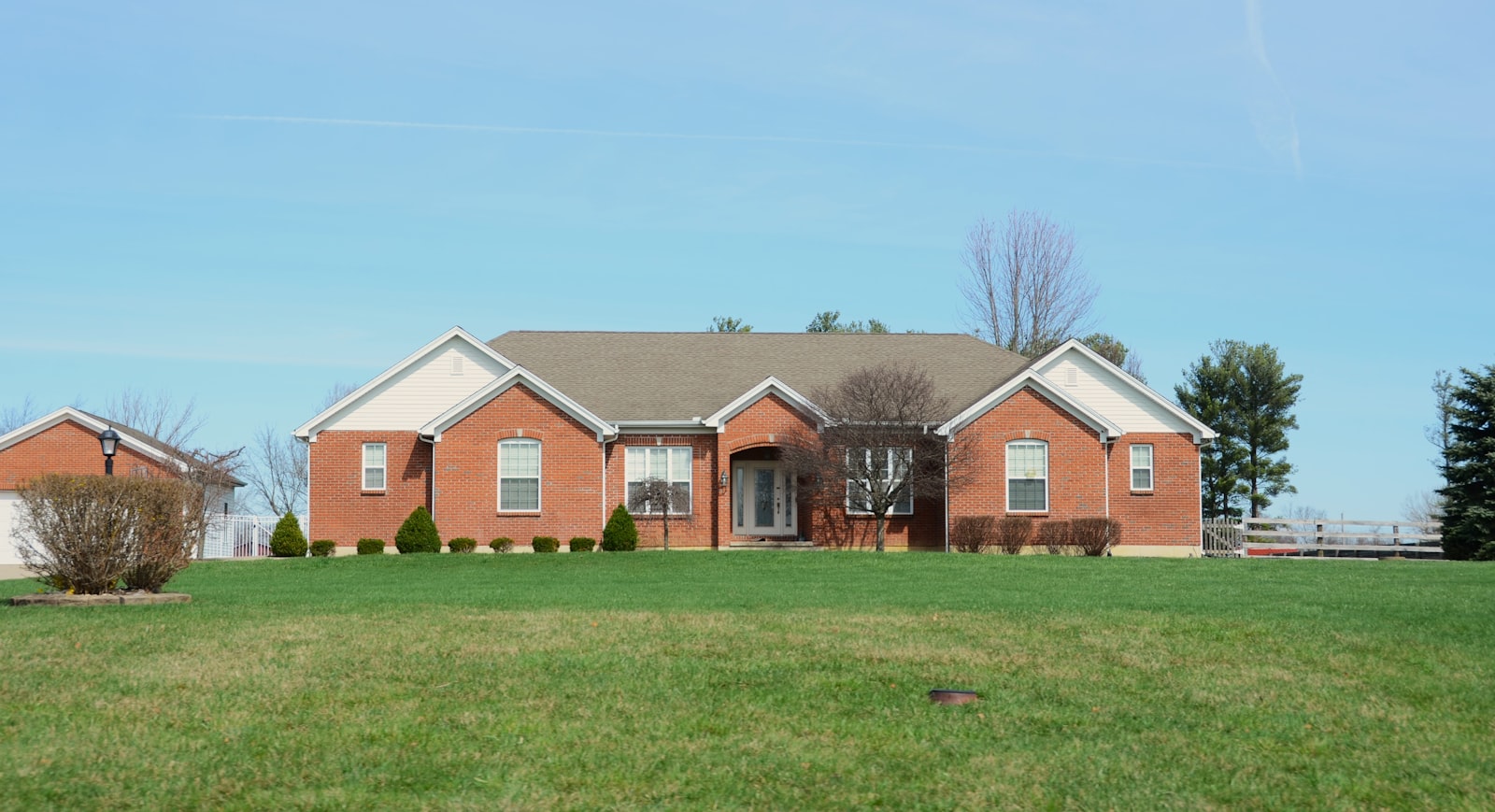 Brick home in Conroe with a freshly mowed lawn and edged front walk.